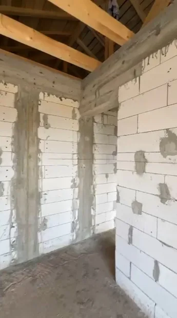 Filmare pe interiorul unei case la roșu, cu zidărie din BCA, stâlpi și centuri de beton și șarpantă din lemn